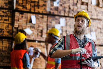 workers man and woman engineering walking and inspecting with working suite dress and hand glove in the front machine. Concept of smart industry worker operating. Wood factories produce wood timber.