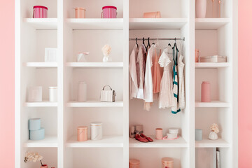 Fototapeta na wymiar Elegant open wardrobe in modern, pastel-toned room