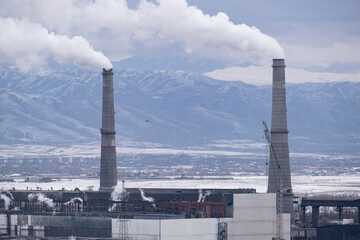 combined heat and power plant, large pipes emitting smoke and harmful substances against the...