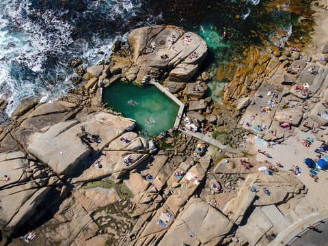 Aerial view of swimmers and beach goers at Saunder&rsquo;s Rock tidal pool in summer in Bantry Bay, Atlantic Seaboard, Cape Town, South Africa.