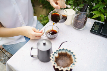 Happy Asian beautiful woman making a specialty coffee in morning at her backyard garden, woman...