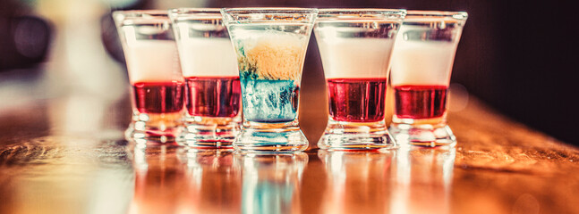Colorful shots at the club. Alcoholic drink in different colors. Tequila shots, vodka, whisky. Set...
