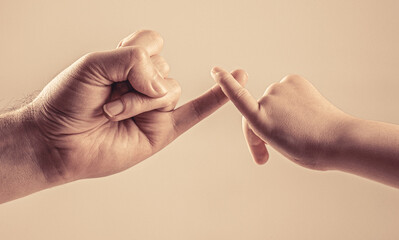 Little finger of the two hands hold together. Father, daughter hand making promise friendship concept. Child hook little finger together