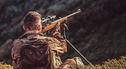 Stoff pro Meter Shooter sighting in the target. The man is on the hunt. Hunt hunting rifle. Hunter man. Hunting period. Male with a gun. Close up. Hunter with hunting gun and hunting form to hunt. Hunter is aiming © Yevhen