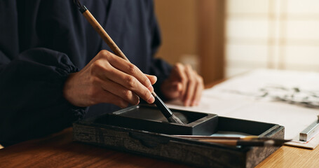 Hands, brush in ink for writing and Japanese calligraphy or ancient script for art and inkstone....
