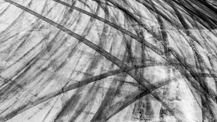 Tire track mark on asphalt tarmac road race track texture and background, Abstract background black tire tracks skid on asphalt road in racing circuit, Tire mark skid mark on asphalt road. © Darunrat