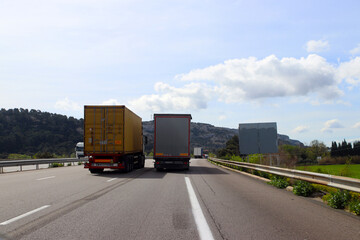 Overtaking trucks on a three lane highway from behind - 710735526