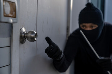 burglar attempting to break into a house - obrazy, fototapety, plakaty
