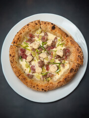 Neapolitan pizza with high edges 4 cheeses and fresh sausage top view on white plate.