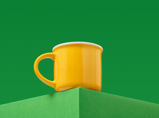 Yellow brightly colored beverage cup on a green background.