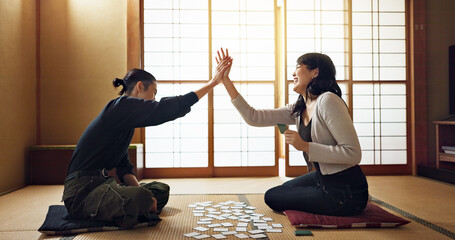 Man, woman and game with cards, high five and challenge on floor, contest or problem solving with...