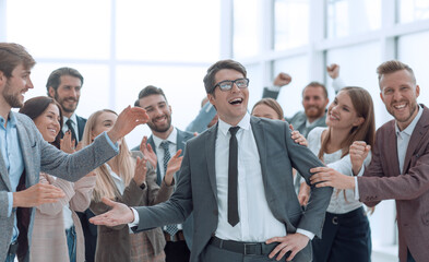 Obraz premium happy business man standing among his colleagues.