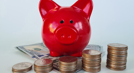 Stack of coins in ascending order and red piggy bank on table us dollar