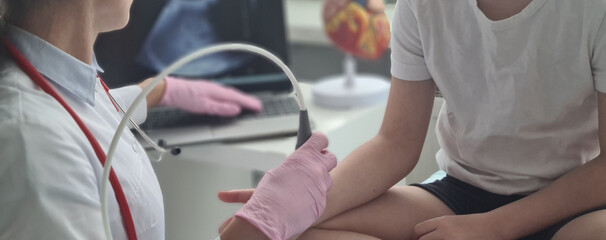 Doctor conducts ultrasound examination of patient child wrist - obrazy, fototapety, plakaty