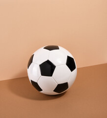 Soccer ball on a beige background. Sports tools. Energy and movement.
