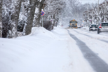 A snowplow is coming, cleaning the snow after a heavy snowfall in a harsh winter