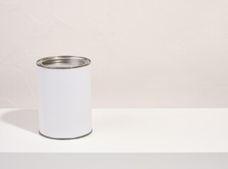 A white can of paint stands on the table. Copy space for text. Work and renovation.