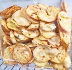 Smoked provolone cheese chips, Thin slices of smoked provolone cheese, for sale in a store that sells by the kilo.