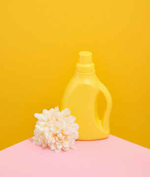 Laundry day on weekend. Yellow bottle of laundry detergent. Fresh beautiful flowers.
