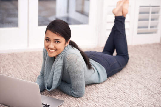Portrait of woman on floor with laptop, smile and relax with studying, college research and browse on web. University student girl on carpet with computer, elearning and online education in home.