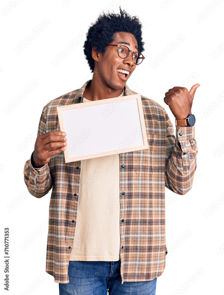 Poster handsome african american man with afro hair holding blank empty banner pointing thumb up to the sid