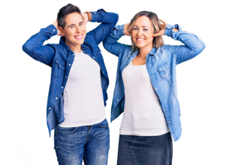 Couple of women wearing casual clothes relaxing and stretching, arms and hands behind head and neck smiling happy