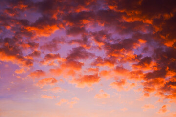 Rich orange and purple hues in sky at dusk, cloud-focused.