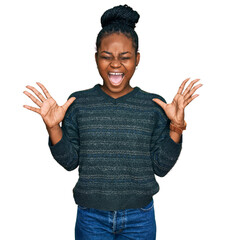 Young african american woman wearing casual clothes celebrating mad and crazy for success with arms...