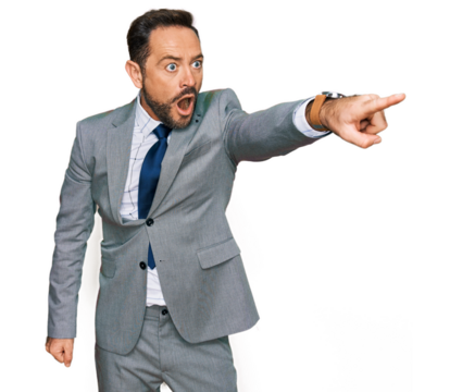 Middle age man wearing business clothes pointing with finger surprised ahead, open mouth amazed expression, something on the front