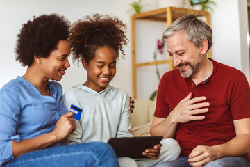 Family Using Digital Tablet And Credit Card At Home