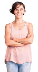 Beautiful young woman with short hair wearing casual style with sleeveless shirt happy face smiling with crossed arms looking at the camera. positive person.