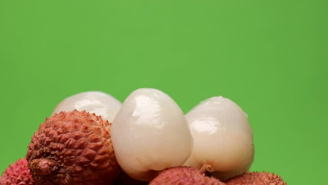 Lychee fruits, rotation in circle. tropical fruit lychee, Turning. selective focus. hill of lychee berries  on a green background 
 