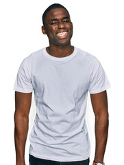 Young african american man wearing casual white t shirt winking looking at the camera with sexy...
