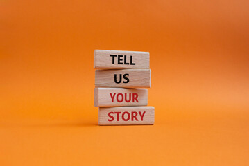 Tell us your story symbol. Concept words Tell us your story on wooden blocks. Beautiful orange background. Business and Tell us your story concept. Copy space.