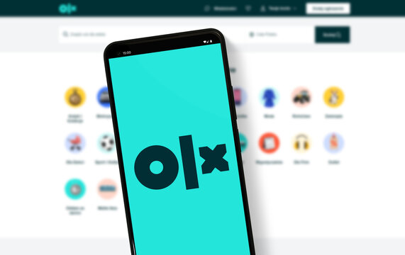 olx logo on mobile phone and desktop with website platform in background - Warsaw, Poland - 16.01.2024