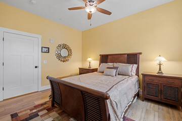 bedroom with yellow walls and hardwood floor, wood sleigh bed, nightstands