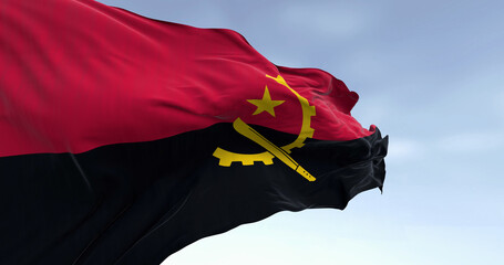 Close-up of Angola national flag waving in the wind on a clear day