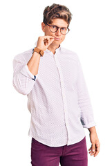 Young handsome man wearing business clothes and glasses mouth and lips shut as zip with fingers. secret and silent, taboo talking