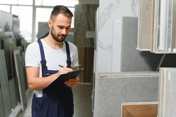 Plumber in uniform at showcase in plumbering store