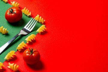 vibrant composition fusilli pasta and ripe tomatoes placed on red and green background, inspired by...