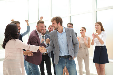 young business man accepting congratulations from his colleagues .
