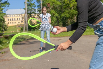 Young couple playing badminton in the park. Focus on racket

