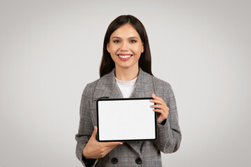 Smiling woman presenting blank tablet screen, interactive display