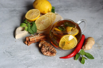 Herbal tea with mint, ginger, lemon and spices on textured background with copy space. Homemade medicine concept. Natural organic drink for cold period.