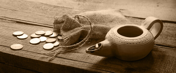 Pouch with silver coins on a wooden table - obrazy, fototapety, plakaty