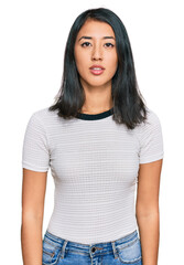 Fototapeta premium Beautiful asian young woman wearing casual white t shirt relaxed with serious expression on face. simple and natural looking at the camera.