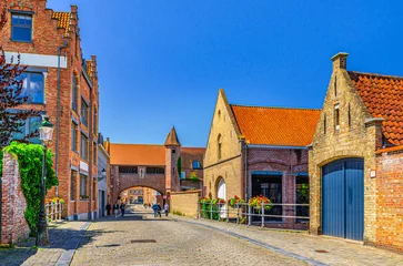 Poster Bruges cityscape with buildings of Art Gallery Koetshuis and Zonnekemeers Gate with brick walls in Brugge city historical centre, Bruges old town quarter medieval district, Flemish Region, Belgium © Aliaksandr