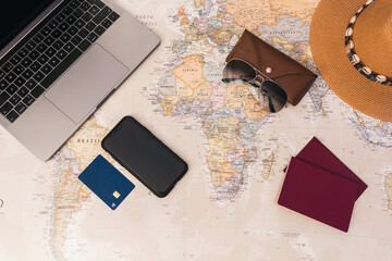 Fototapeta na wymiar Desk world map with passport, laptop, hat, credit card and smartphone copy space