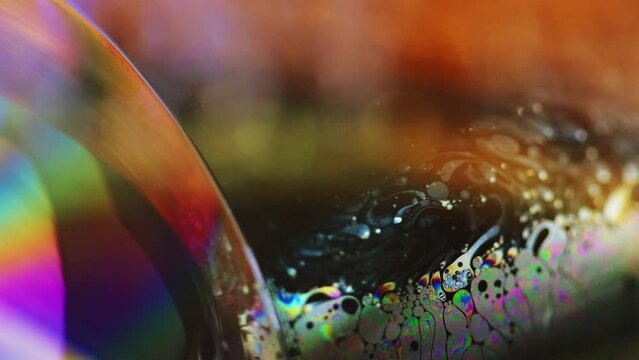 Soap bubble. Rainbow lens flare. Psychedelic dream. Defocused bright colorful transparent oil paint liquid sphere abstract art background with free space.