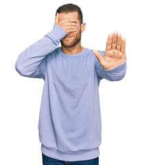 Young caucasian man wearing casual clothes covering eyes with hands and doing stop gesture with sad and fear expression. embarrassed and negative concept.